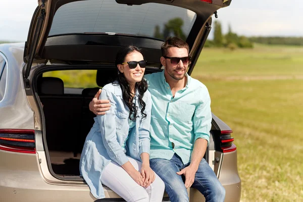 Щаслива пара обіймає відкритий багажник автомобіля — стокове фото