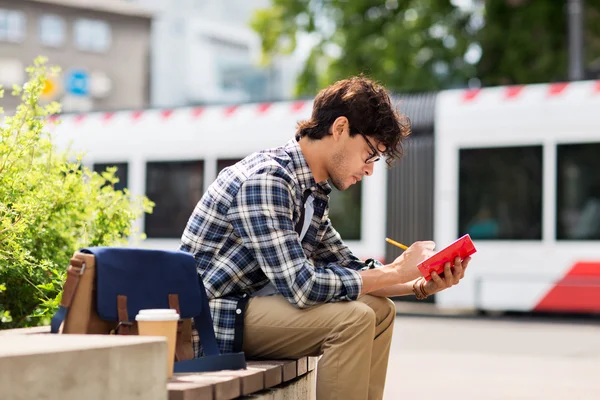 Man met laptop of dagboek schrijven op stad straat — Stockfoto