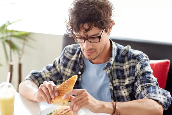 Felice uomo mangiare panino al caffè per pranzo — Foto Stock