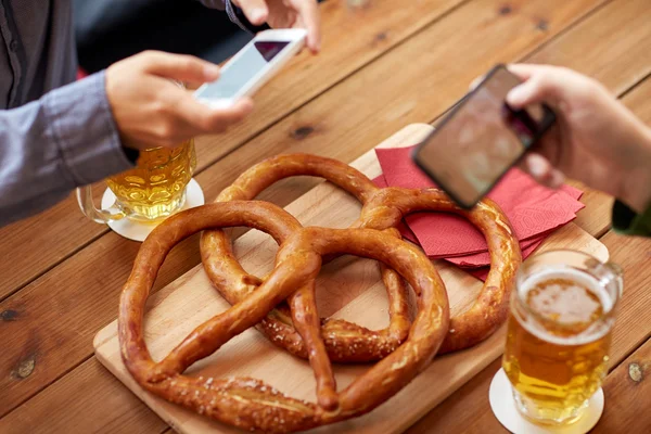 Primer plano de las manos imaginando pretzel por teléfono inteligente — Foto de Stock