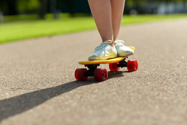 Close up van vrouwelijke voeten rijden korte skateboard — Stockfoto