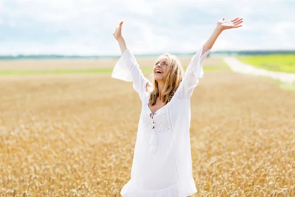 Улыбающаяся молодая женщина в белом платье на зерновом поле — стоковое фото