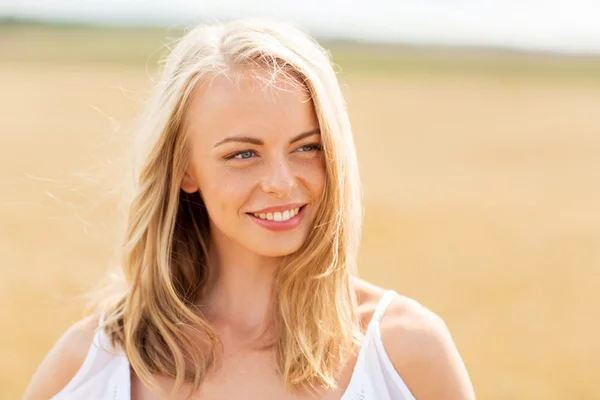 Lachende jonge vrouw in wit op granen veld — Stockfoto