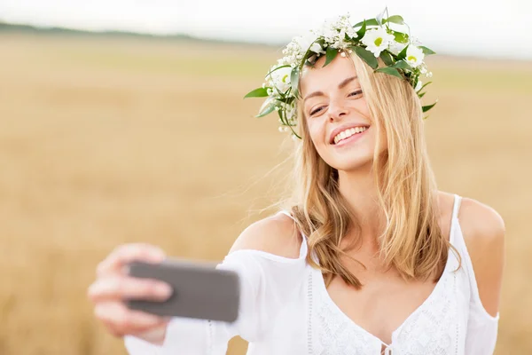 Mutlu genç bir kadın akıllı telefondan selfie çekiyor. — Stok fotoğraf