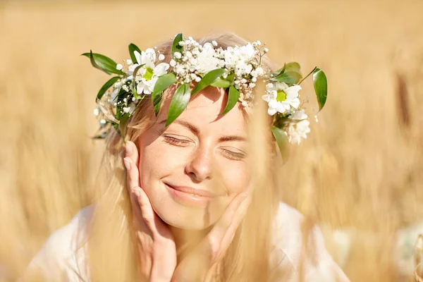 Happy woman in wreath of flowers on cereal field — Stock Photo, Image