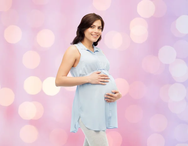 Glad gravid kvinna röra hennes stora mage Stockbild