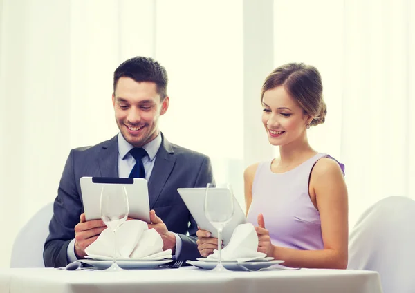 Couple with menus on tablet pc at restaurant — Stock Photo, Image
