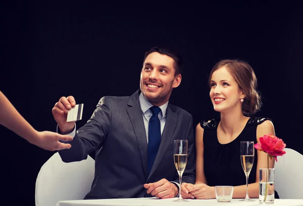 Couple souriant payant pour le dîner avec carte de crédit — Photo