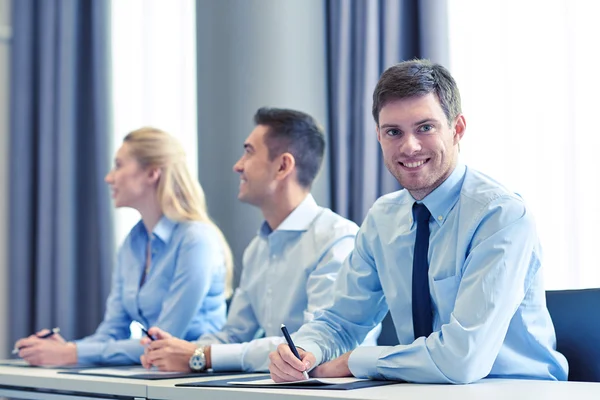 Grupo de empresarios sonrientes reunidos en el cargo — Foto de Stock