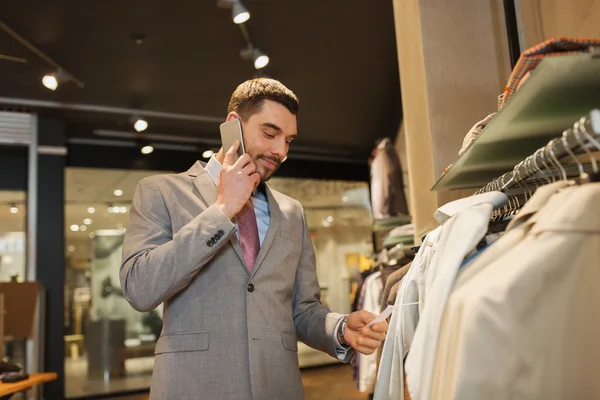 Gelukkig man opgeroepen smartphone bij kledingwinkel — Stockfoto