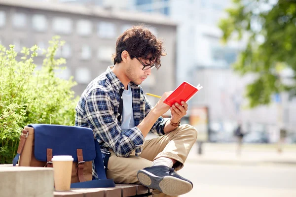 Man with notebook or diary writing on city street — Stock Photo, Image