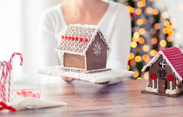 Kadın gösteren gingerbread evi yakın çekim — Stok fotoğraf