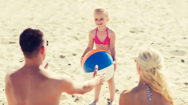 Gelukkige familie spelen met opblaasbare bal op strand — Stockfoto