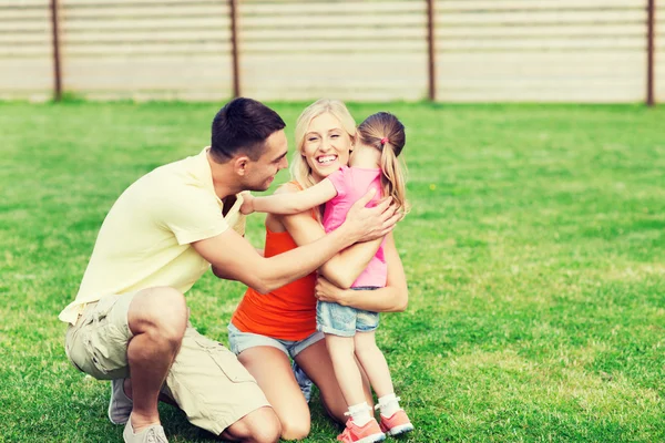 Família feliz abraçando ao ar livre — Fotografia de Stock