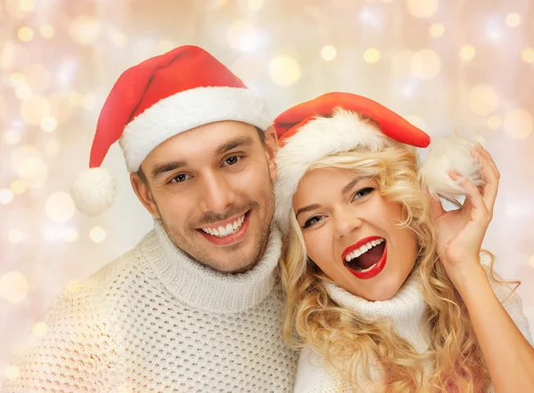 Glückliches Familienpaar in Pullovern und Weihnachtsmützen — Stockfoto