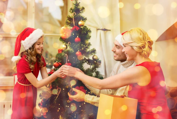 Smiling family decorating christmas tree — Stock Photo, Image