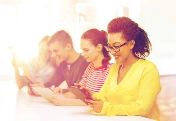 Studenti sorridenti guardando tablet pc a scuola — Foto Stock