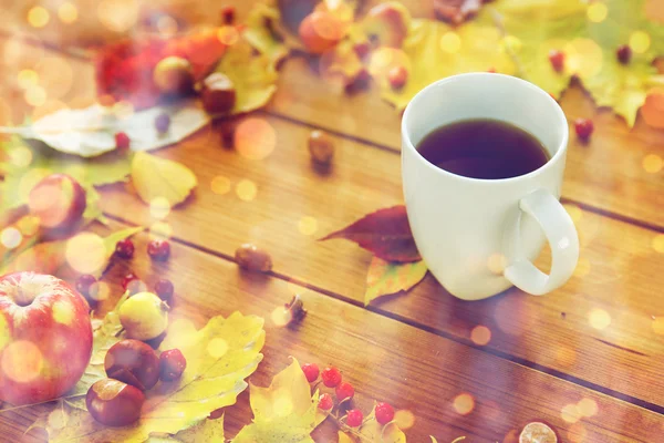 Primer plano de la taza de té en la mesa con hojas de otoño — Foto de Stock