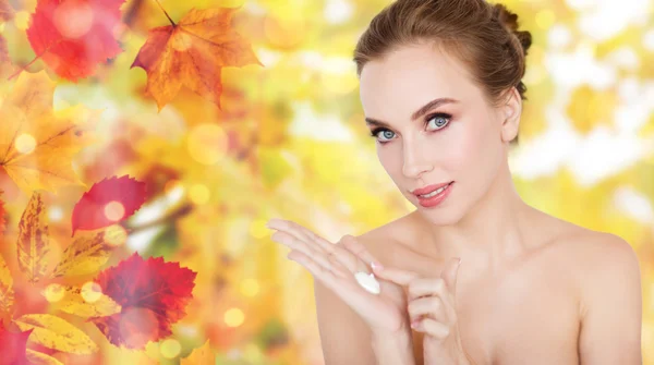 Happy young woman with moisturizing cream on hand — Stock Photo, Image