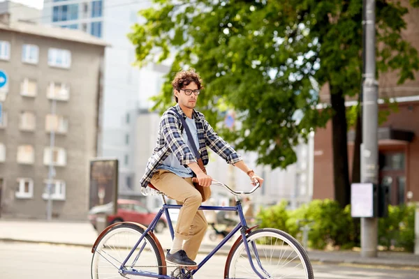 Çantalı genç hippi sabit vitesli bisiklet sürüyor. — Stok fotoğraf