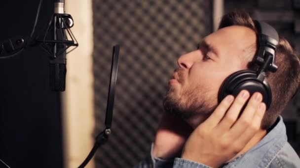 Homem com fones de ouvido cantando no estúdio de gravação — Vídeo de Stock