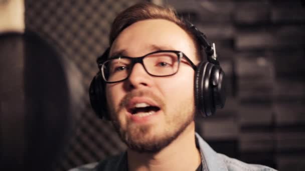 Hombre con auriculares cantando en el estudio de grabación — Vídeos de Stock