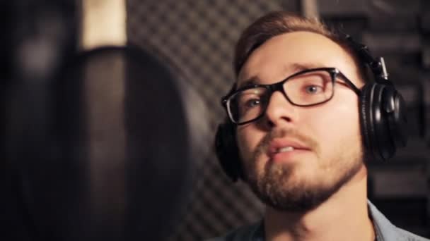 Man with headphones singing at recording studio — Stock Video