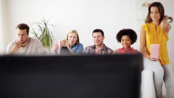 Amigos felices con palomitas de maíz viendo la televisión en casa — Vídeos de Stock