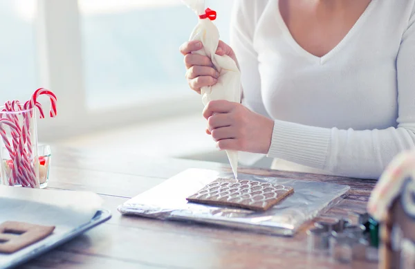 Primer plano de la mujer haciendo casas de pan de jengibre — Foto de Stock