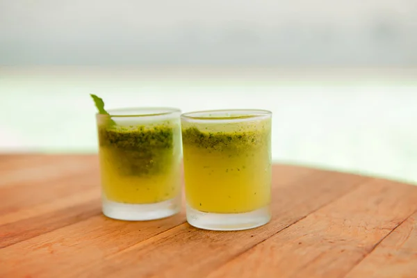 Bicchieri di succo di frutta fresco o cocktail sulla spiaggia — Foto Stock