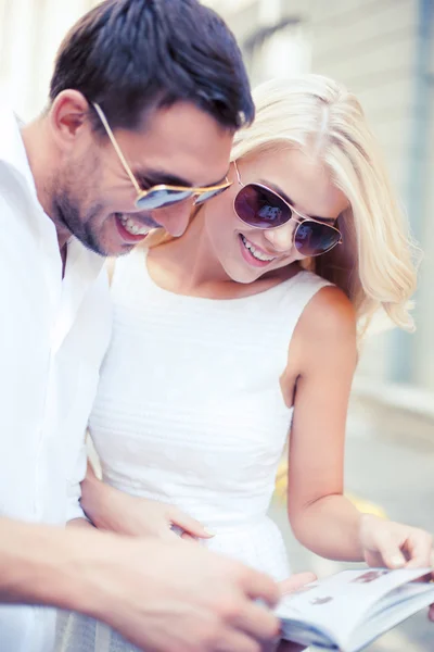 Couple with tourist book in the city — Stock Photo, Image