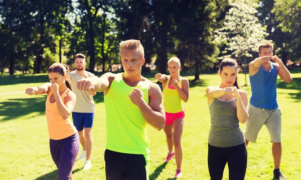 Grupo de amigos o deportistas que hacen ejercicio al aire libre — Foto de Stock