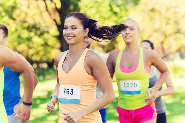 Feliz joven deportistas carreras ingenio insignia números — Foto de Stock