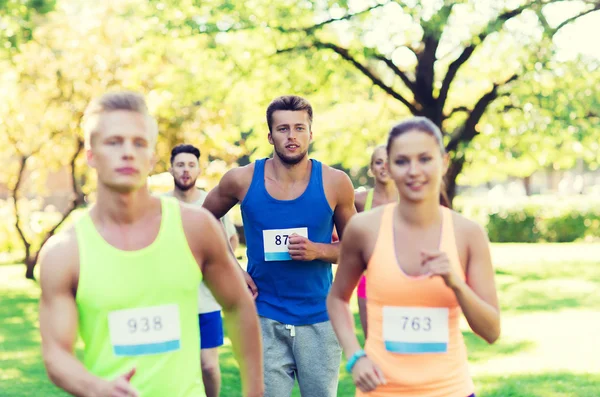 Happ junge Sportler rasen mit Abzeichen-Nummern — Stockfoto