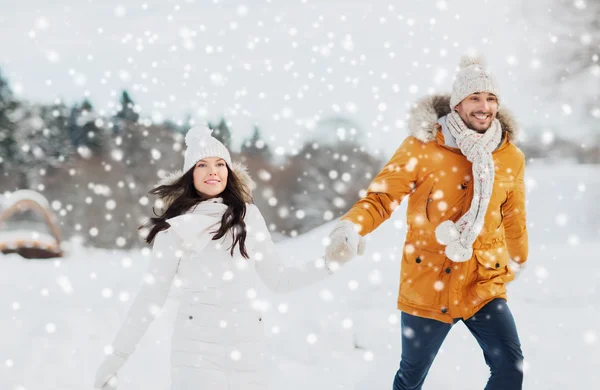 Gelukkige paar lopen over de achtergrond van de winter — Stockfoto