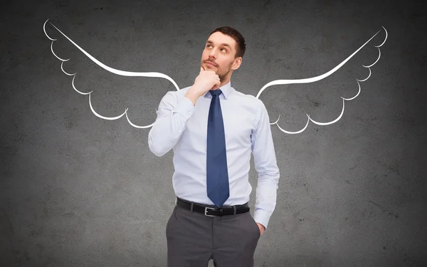 Businessman with angel wings over gray — Stock Photo, Image