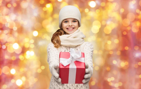 Happy girl in hat, scarf and gloves with gift box — Stock Photo, Image