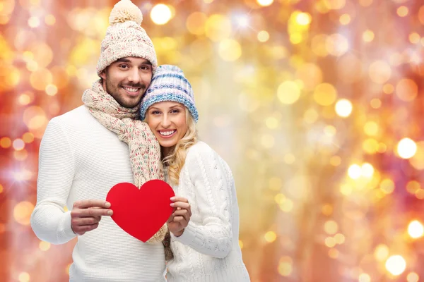 Casal sorridente em roupas de inverno com corações vermelhos — Fotografia de Stock