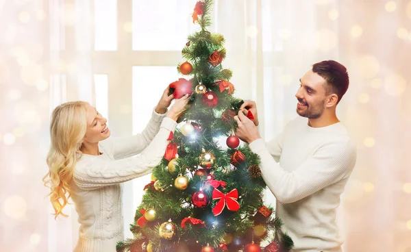 Feliz pareja decorando árbol de Navidad en casa — Foto de Stock
