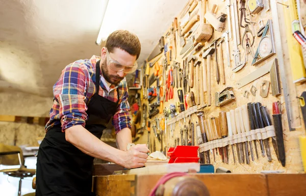 Carpenter working with plane and wood at workshop — Stock Photo, Image