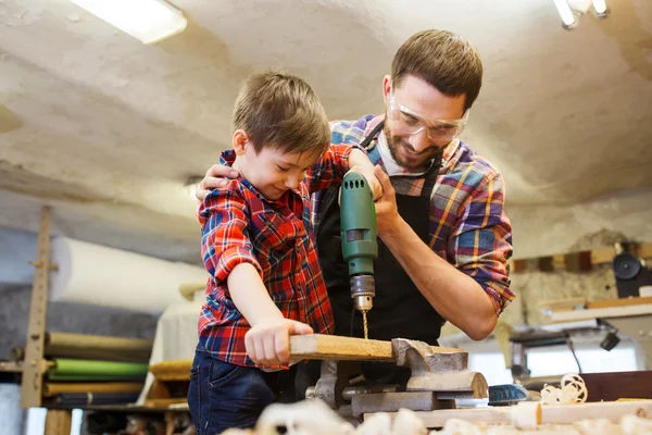 Vater und Sohn mit Bohrmaschine bei Werkstattarbeiten — Stockfoto