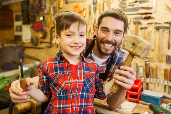 Pojke med pappa anläggning mejsel och hammare på verkstad — Stockfoto