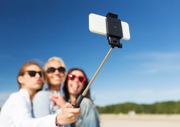 Women with selfie stick and smartphone on beach — Stock Photo, Image