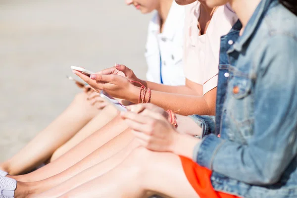 Close up of young women with smartphones on beach — Stock Photo, Image