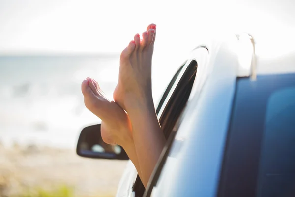 Close up de pés de mulher mostrando da janela do carro — Fotografia de Stock