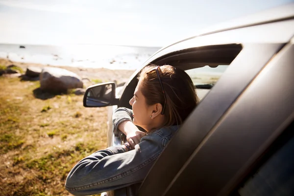 Glückliches Teenager-Mädchen oder junge Frau im Auto — Stockfoto