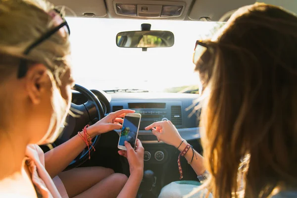 Tiener meisjes of vrouwen met smartphone in de auto — Stockfoto