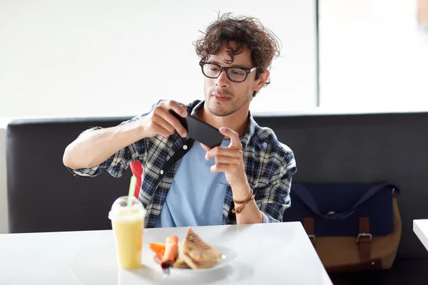 Mann mit Smartphone fotografiert Essen im Café — Stockfoto