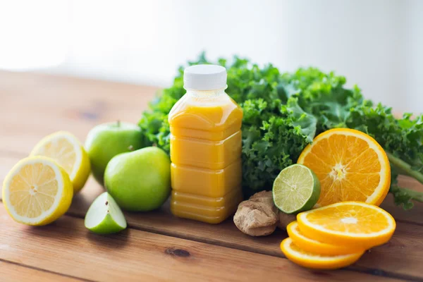 Botol dengan jus jeruk, buah-buahan dan sayuran — Stok Foto