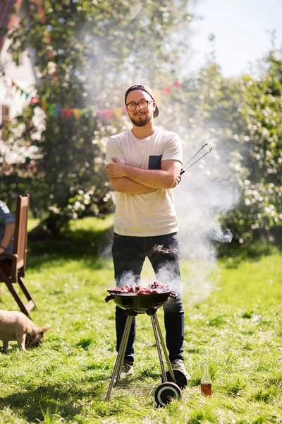 Man cooking meat on barbecue grill at summer party — Stock Photo, Image